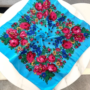 Detail of vintage blue Russian floral scarf with red roses on a marble surface