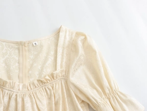 Détail du col carré avec volants et texture jacquard sur la robe beige clair