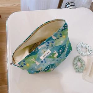 Detail of printed cotton makeup bag with rabbit pattern and wide opening for storage