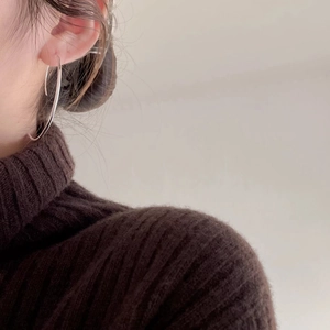 Minimalist 925 sterling silver hoop earrings shown on a model with a brown sweater
