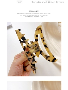 Detail showing high-quality tortoise shell pattern hair claw with gold metal spring hinge