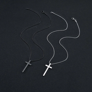 Colliers avec pendentif croix en acier titane noir et argent sur fond texturé