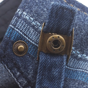 Detail of dark blue denim texture with retro bronze metal buckle and star ornament