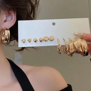 Gold heart stud and hoop earring set for women featuring diverse metallic textures