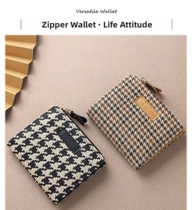 Close-up of houndstooth fabric texture on two zipper wallets in black and brown colors