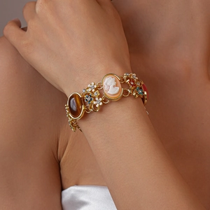 Detail eines Vintage-Goldarmbands mit Cameo-Porträt und Emaille-Blumenanhängern
