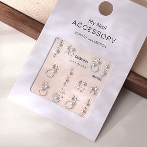 Detail of 3D French pearl and silver star nail charms with gold metallic accents