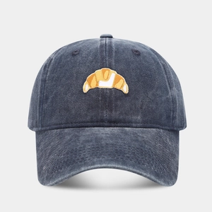 Close-up of croissant embroidery on washed cotton baseball cap with vintage texture