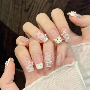 Pink bow press-on nails with sweet plaid and dot patterns in a glossy trapezoid shape