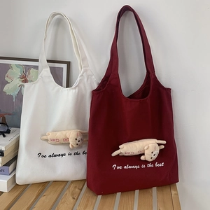 Detail of canvas tote bags in white and burgundy with cute plush cat pendant