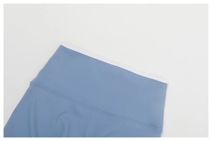 Dettaglio macro dei leggings yoga blu a vita alta con bordo a contrasto bianco e cuciture piatte