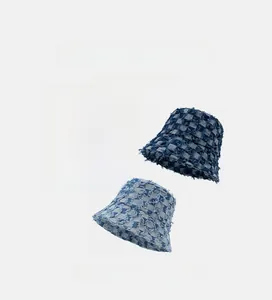 Detail of checkerboard bucket hats showing frayed edges in black, navy, and light blue denim