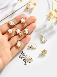 Detailed view of white enamel turtle pendant with gold plating and size measurements