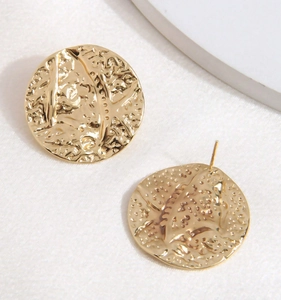 Detail macro shot of gold stainless steel round earrings with irregular bumpy texture