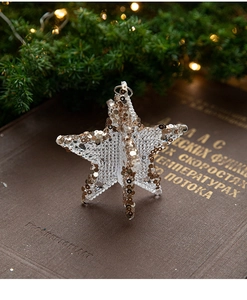 Macro detail of star shaped Christmas ornament with gold and silver sequins on mesh