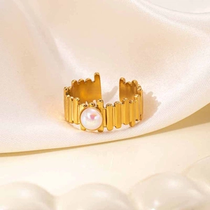 Detail of vintage 18K gold plated striped ring with a round pearl stone on silk
