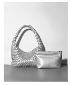 Dettaglio della borsa intrecciata argento e pochette abbinata con finitura metallica