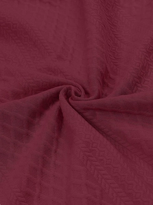 Gros plan sur le tissu bordeaux avec une texture jacquard géométrique détaillée