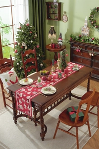Detail of red Christmas table runner with white snowflake patterns and tassel on wood table