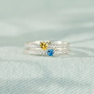 Dettaglio dell'anello a doppio strato in argento con gemme a cuore gialle e blu