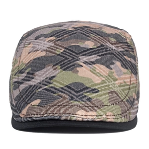 Close-up of woodland camouflage flat cap featuring textured canvas fabric and black piping