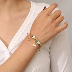 Detail of colorful star charm beaded bracelet worn on wrist with gold stainless steel beads