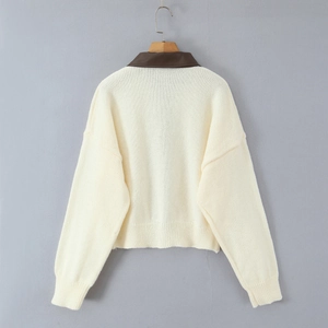 Cream knit cardigan with brown leather collar and dropped shoulders shown from the back view