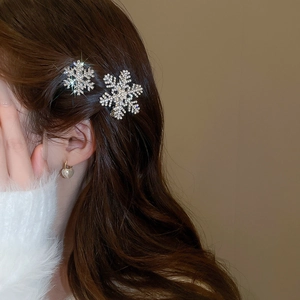 Close-up of sparkling snowflake hair clips with rhinestones on a woman's brown hair