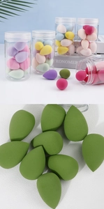 Macro shot of colorful teardrop makeup sponges with fine texture in a clear storage jar