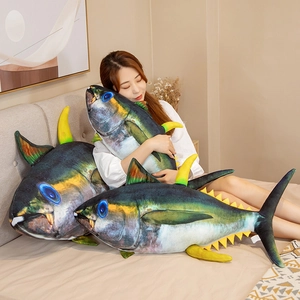 Three sizes of realistic cartoon tuna plush pillows shown on a bed for size reference