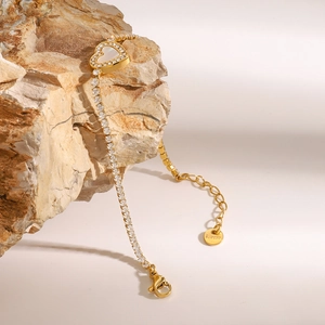 Dettaglio del bracciale cuore dorato con inserti in madreperla e piccoli cristalli