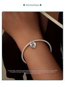 Detail of S925 silver mesh woven bracelet with a polished heart pendant on a wrist