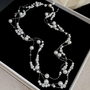 Detail of layered pearl necklace with pavé crystal beads on black jewelry display