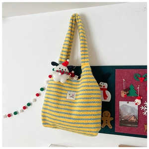 Close-up of fluffy blue and yellow striped tote bag with a cute puppy plush pendant
