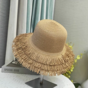 Detailed close-up of straw sun hat featuring a unique fringed edge and woven texture