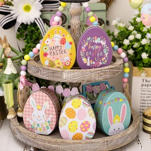 Detailed set of five Easter egg-shaped tin boxes with rabbit and floral patterns