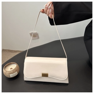 Detail of off-white minimalist underarm bag with wavy flap and gold metallic clasp