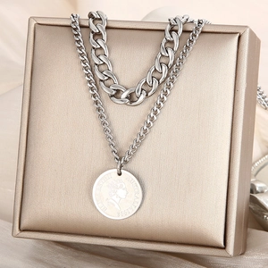 Macro detail of silver double-layered necklace with coin pendant in a jewelry box