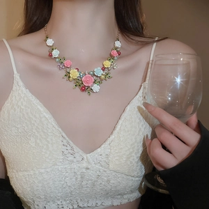 Detail of colorful resin flowers and imitation pearls on a gold-plated floral necklace
