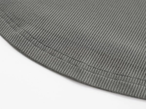Macro shot of grey ribbed knit fabric texture and double-needle hem stitching detail