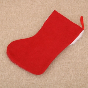 Detail of red felt Christmas stocking with white plush trim and hanging loop on fabric