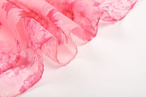 Detail of pink floral chiffon fabric showing elegant drape and light airy texture