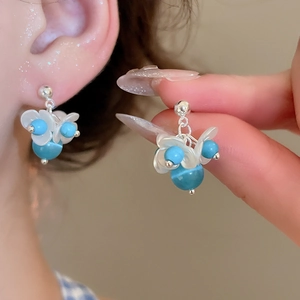 Detailed close-up of S925 silver needle pearl flower earrings with blue bead accents
