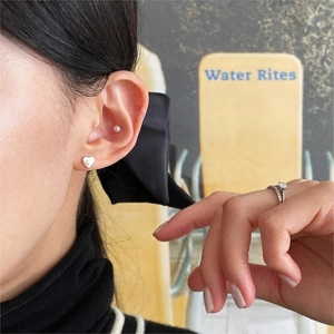 Minimalist 925 sterling silver heart and pearl stud earrings worn by female model