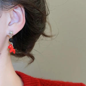 Detail view of red pony drop earring with silver needle on a model showing actual scale
