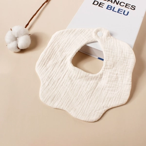 Detailopname van de zachte witte katoenen gaas baby slabbetje in bloemvormige textuur