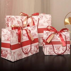 Three assorted floral gift bags with red butterfly patterns and elegant ribbon handles
