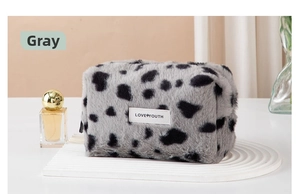 Close-up of gray leopard faux fur makeup bag with LOVE YOUTH label and soft plush texture