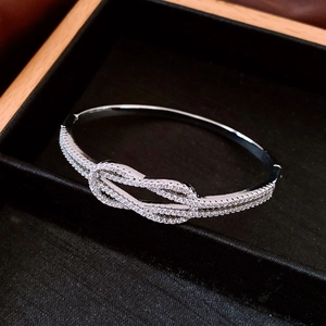 Détail d'un bracelet nœud argenté avec strass brillants dans son écrin noir élégant