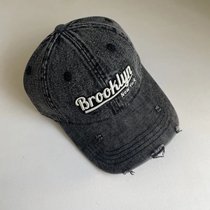 Macro view of distressed washed denim baseball cap with 3D Brooklyn New York embroidery